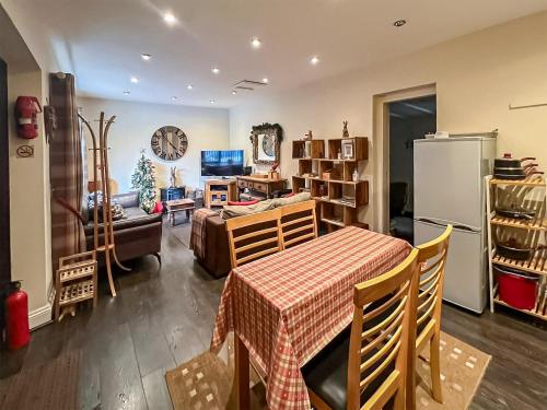 a kitchen and living room with a table and a refrigerator at Ringinglow Toy Cottage in Fulwood