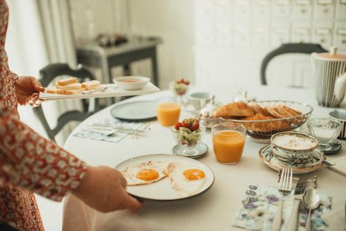 osoba siedząca przy stole z jajkami na talerzu w obiekcie La Maison des Dames 