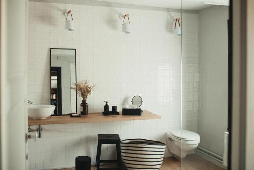 ein Badezimmer mit einem Waschbecken, einem WC und einem Spiegel in der Unterkunft La Maison des Dames 