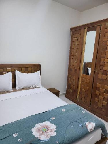 - une chambre avec un lit doté d'une couverture bleue et d'une fenêtre dans l'établissement JADO House, à Dakar