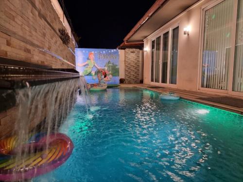 a swimming pool with a water fountain in a building at Peter Pan Poolvilla in Jomtien Beach