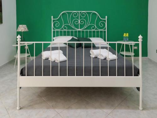 1 dormitorio con 1 cama con pared verde en La Darsena Fiumicino, en Fiumicino