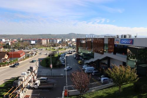 a city street with cars parked in a parking lot at Swiss Apartmani in Banja Luka