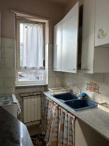 une cuisine avec un évier et une fenêtre dans l'établissement Da Tiziana, à Turin