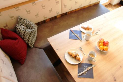 a wooden table with plates of food on it at Apart Sunny Side in Ramsau im Zillertal