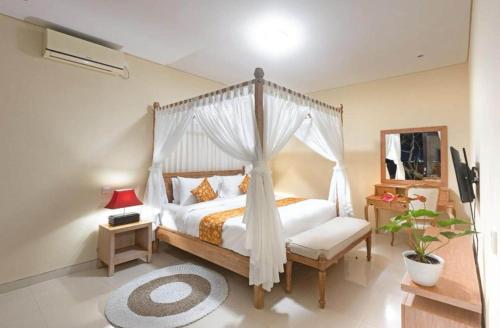 Elegant 6 Bedrooms Luxury Villa Near Pandawa Beach في نوسا دوا: غرفة نوم مع سرير مظلة مع إطار سرير أبيض