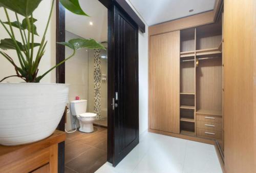La salle de bains est pourvue de toilettes et d'une plante en pot. dans l'établissement Elegant 6 Bedrooms Luxury Villa Near Pandawa Beach, à Nusa Dua