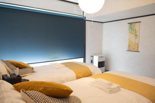 two beds in a room with a large window at Niseko Powder Chalet in Kutchan
