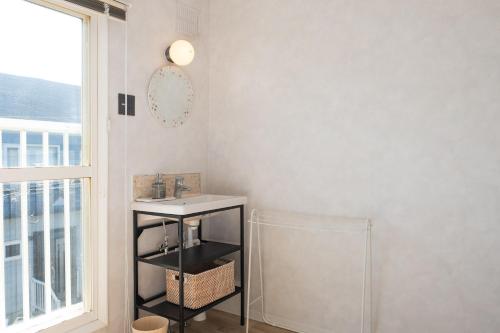 een badkamer met een wastafel, een spiegel en een raam bij Niseko Powder Chalet in Kutchan