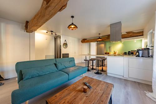 a living room with a blue couch and a wooden table at Le bel appart T3 Grisolles in Grisolles