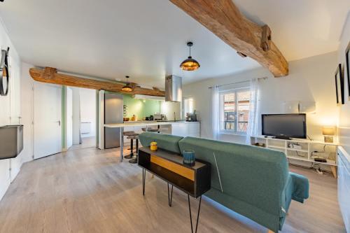 a living room with a green couch and a table at Le bel appart T3 Grisolles in Grisolles
