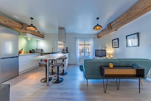 a kitchen and living room with a couch and a table at Le bel appart T3 Grisolles in Grisolles