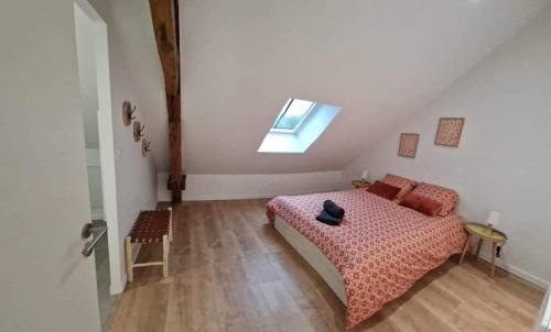 ein kleines Schlafzimmer mit einem Bett und einem Dachfenster in der Unterkunft Appartement de charme Cormontreuil Reims in Cormontreuil