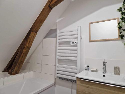 ein weißes Badezimmer mit einem Waschbecken und einer Treppe in der Unterkunft Appartement de charme Cormontreuil Reims in Cormontreuil