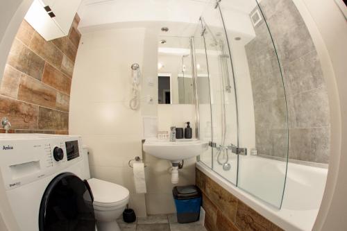 uma casa de banho com um WC, um chuveiro e um lavatório. em Apartament Książęcy przy Pałacu - klimatyzacja em Zagań
