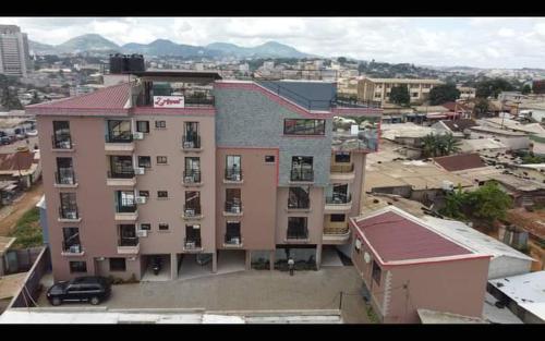 un gran edificio con un estacionamiento en una ciudad en Résidence l'Appart, en Yaoundé