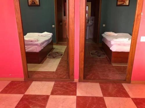 a room with two mirrors and two beds in a room at Hrashq Hotel in Yerevan