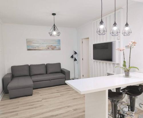 a living room with a couch and a table at Santo António Guest Apartment in Funchal