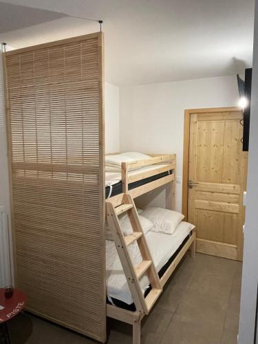 Cette chambre comprend 2 lits superposés et une porte. dans l'établissement Dans résidence neuve LE SNOW ROC sur les pistes, grand studio cosy 5 pers avec terrasse panoramique, SAUNA, WIFI, à Saint-Jean-dʼAulps