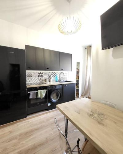une cuisine avec lave-linge, sèche-linge et une table dans l'établissement Corte tres beau T2 neuf hyper centre 4 personnes calme et lumineux wifi lave linge, à Corte