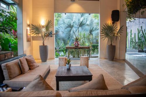 a lobby with a couch and a table and plants at The White Palms of Nosara in Nosara