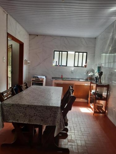 a dining room with a table and a kitchen at Casadateca in Praia Vermelha