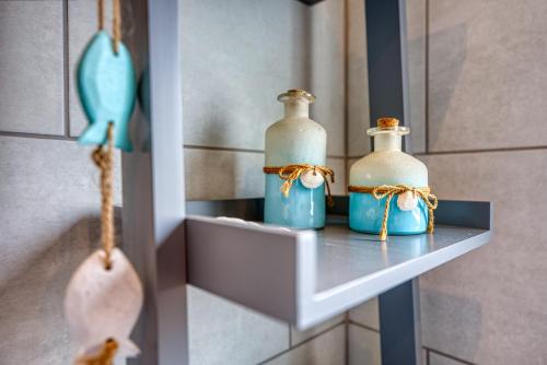 three bottles sitting on a shelf in a room at Modern 2-Bed Stylish Contractor House, Prime Portsmouth Location & Parking - By Blue Puffin Stays in Portsmouth