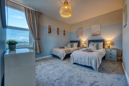 a bedroom with two beds and a window at Modern 2-Bed Stylish Contractor House, Prime Portsmouth Location & Parking - By Blue Puffin Stays in Portsmouth