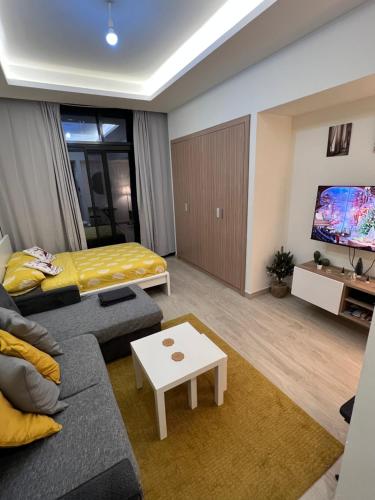 a living room with a couch and a bed at Modern Studio Center of Dubai in Dubai