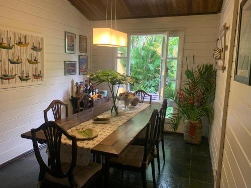 - une salle à manger avec une table et des chaises en bois dans l'établissement Chalé de Madeira na Mata Atlântica e perto do Mar, à Angra dos Reis