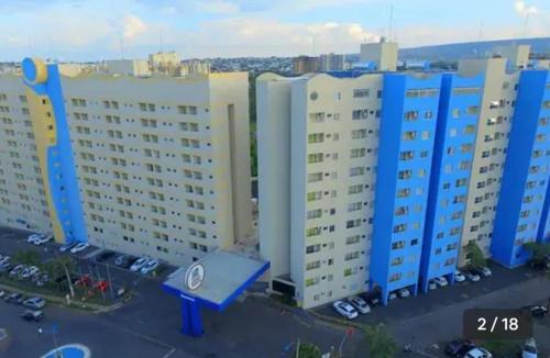 a group of tall buildings in a parking lot at Flat - Condomínio Golden Dolphin Express in Caldas Novas