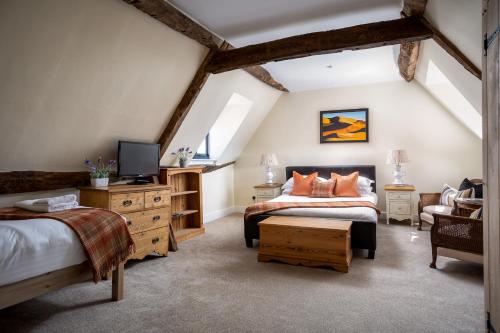 a attic bedroom with two beds and a tv at Bantam Tea Rooms in Chipping Campden