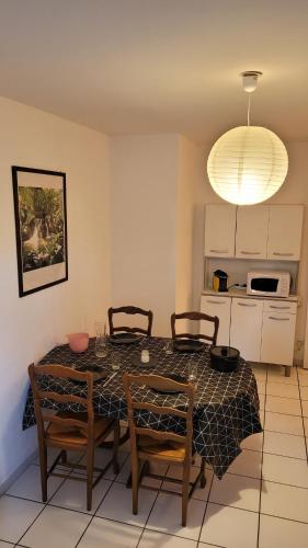 a dining room with a table and chairs and a kitchen at Appartement T2 imm. La Villa d'Este in Digne-les-Bains