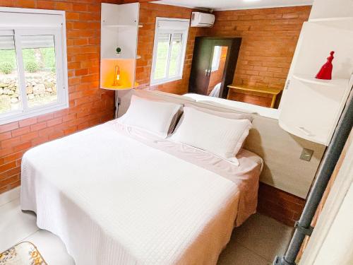 um quarto com uma cama e um espelho em Pousada do Bosque Bento em Bento Gonçalves