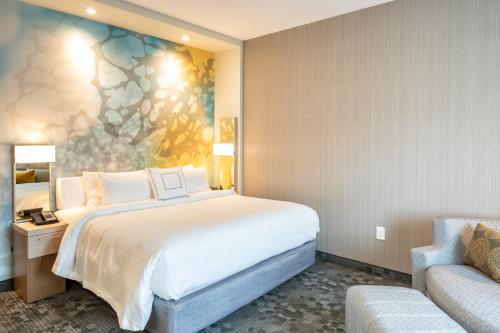 um quarto de hotel com uma cama e uma cadeira em Courtyard by Marriott Charleston-North Charleston em Charleston