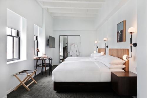 a white bedroom with a large bed and a desk at The Guild Hotel San Diego Downtown, a Marriott Tribute Portfolio Hotel in San Diego