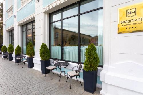 a row of chairs and tables in front of a building at Newport Hotel Kutaisi in Kutaisi
