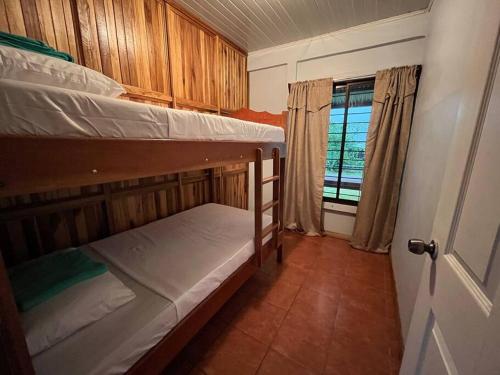 um pequeno quarto com 2 beliches e uma janela em Rustical House Celeste em Bijagua