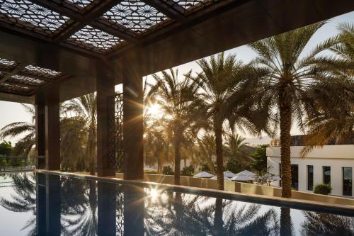 a view of the pool at a resort with palm trees at JW Marriott Hotel Muscat in Muscat