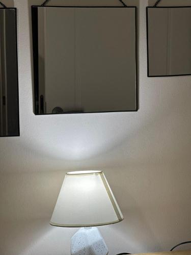 a lamp on a wall with a mirror at LARDA TBILISI in Tbilisi City