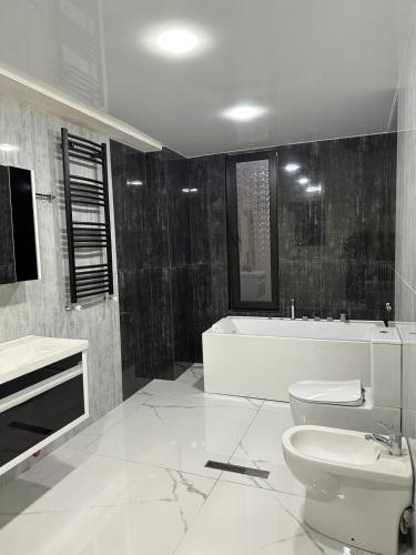 a bathroom with a tub and a toilet and a sink at LARDA TBILISI in Tbilisi City