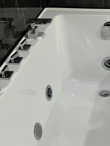 a white bathroom sink with aaucet at LARDA TBILISI in Tbilisi City