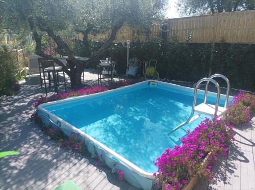 einen Pool in einem Garten mit Blumen in der Unterkunft HomArt roof roman king in Borghesiana 