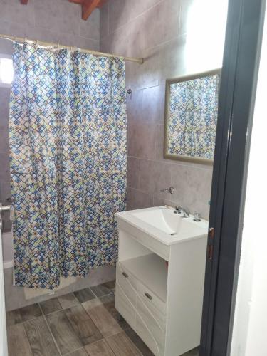 a bathroom with a sink and a shower curtain at APART SOFIA in Termas de Río Hondo