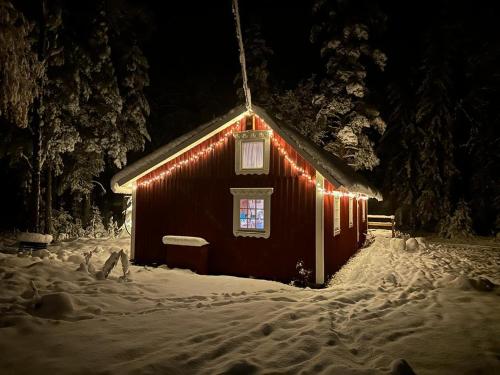 a barn covered in lights in the snow at night at Davids Stuga in Klässbol