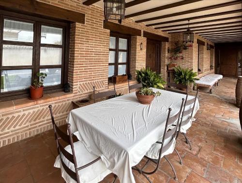 comedor con mesa, sillas y ventanas en La Flor del Granado en Torrijos