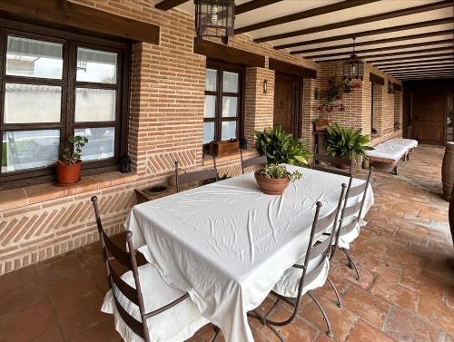 a dining room with a table and chairs and windows at La Flor del Granado in Torrijos