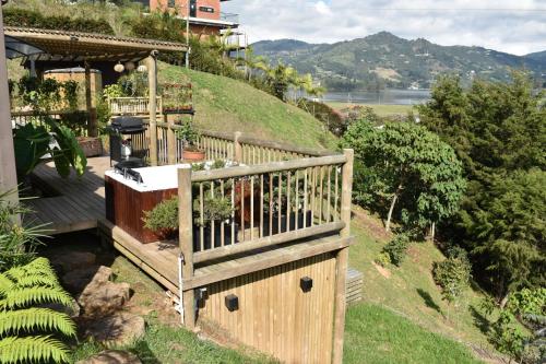 a wooden fence on a hill next to a house at EL PAISAJE MAS SOÑADO in El Retiro