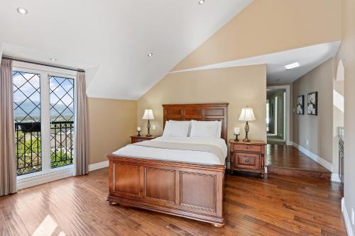 a bedroom with a large bed and a window at Grand English Style Home in Chilliwack