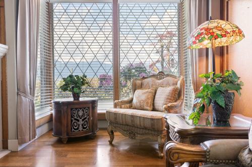 a living room with a chair and a large window at Grand English Style Home in Chilliwack
